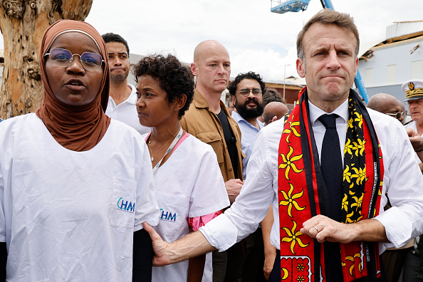 Le Président Emmanuel Macron à côté d'un membre du personnel médical au centre hospitalier de Mayotte à Mamoudzou, le 19 décembre 2024, après le passage du cyclone Chido sur l'archipel. (Photo LUDOVIC MARIN/POOL/AFP via Getty Images)