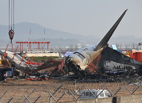 La scène où un Boeing 737-800 de Jeju Air s'est écrasé et a pris feu est visible à l'aéroport international de Muan, à quelque 288 kilomètres au sud-ouest de Séoul, le 30 décembre 2024.   (Crédit photo : JUNG YEON-JE/AFP via Getty Images)