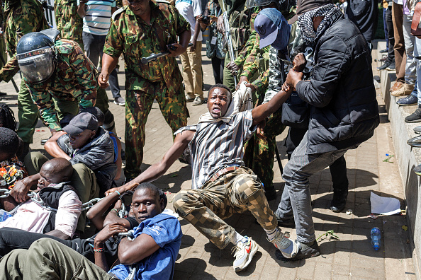 La police anti-émeute tente de disperser et d'arrêter les manifestants accroupis au sol au cours des manifestations pour demander la libération des personnes qui auraient été enlevées par les agences de sécurité de l'État à Nairobi, le 30 décembre 2024. (TONY KARUMBA/AFP via Getty Images)