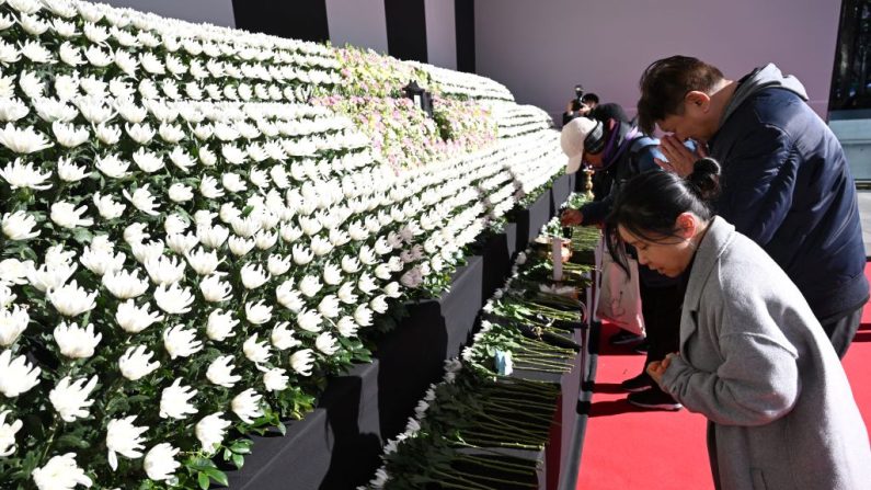 Des personnes en deuil se recueillent devant l'autel commémoratif des victimes de l'accident d'avion de Jeju Air, devant l'hôtel de ville de Séoul, le 31 décembre 2024. (Photo : JUNG YEON-JE/AFP via Getty Images)