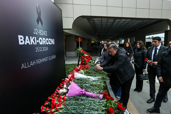 Des citoyens déposent des fleurs en mémoire des victimes de l'Embraer 190 d'Azerbaijan Airlines, le 26 décembre 2024 à Bakou en Azerbaïdjan. (Aziz Karimov/Getty Images)