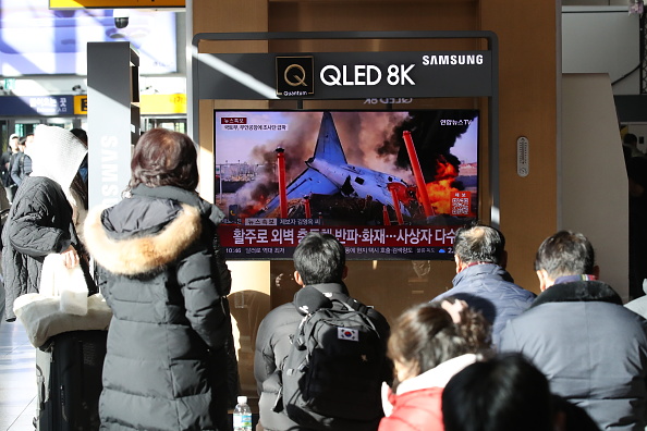 Des personnes regardent les informations concernant l'accident d'avion à la gare de Séoul le 29 décembre 2024 à Séoul, Corée du Sud. (Photo Chung Sung-Jun/Getty Images)