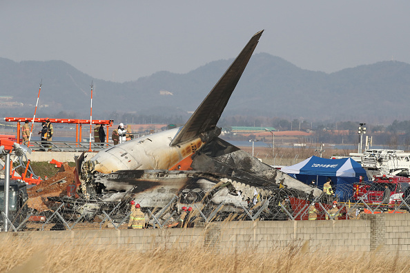 Des pompiers et des équipes de secours travaillent sur l'épave d'un avion de passagers à l'aéroport international de Muan le 29 décembre 2024 à Muan-gun, en Corée du Sud. (Photo Chung Sung-Jun/Getty Images)