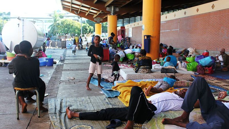 Des étrangers vivant à Mayotte, assis dans un camp de fortune sur la place de la République à Mamoudzou, sur le territoire français de l'océan Indien de Mayotte, le 31 mai 2016, après avoir été expulsés de leurs maisons. 
 (ORNELLA LAMBERTI/AFP via Getty Images)