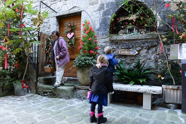 Des enfants regardent une petite crèche à Luceram, le 11 décembre 2016.  (YANN COATSALIOU/AFP via Getty Images)