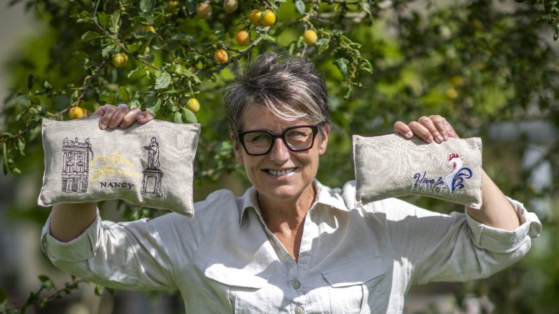 Christelle Larue, créatrice des bouillottes Lorrailes, pose avec des bouillottes sous un mirabellier. (DR)