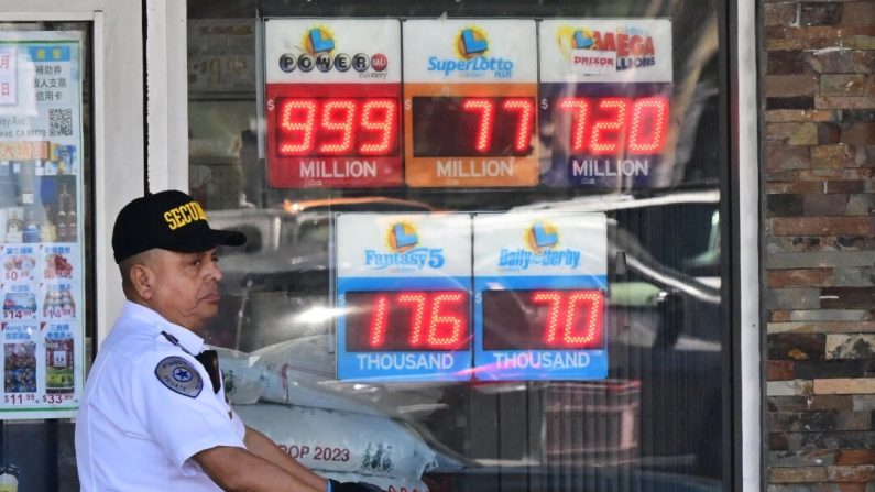 Un agent de sécurité passe devant des panneaux affichant les montants des gains de la loterie à Rosemead, en Californie, le 19 juillet 2023. (Frederic J. Brown/AFP via Getty Images)