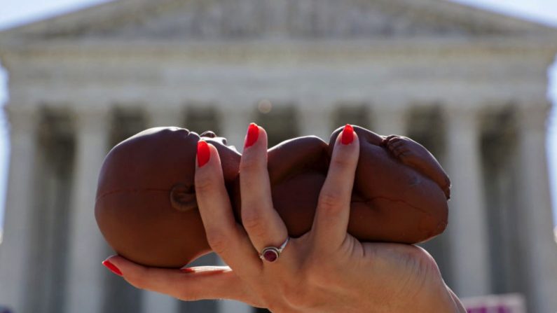 Un militant tient un modèle de fœtus lors d'une manifestation défendant le droit à la vie des foetus, devant la Cour suprême des États-Unis à Washington, le 29 juin 2020. (Alex Wong/Getty Images)