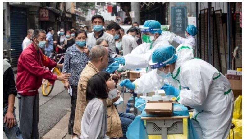 Les infirmiers prélèvent des échantillons d'écouvillons sur les gens pour être testés pour le virus du Covid-19, dans une rue de Wuhan, province chinoise du Hubei, le 15 mai 2020. (STR/AFP via Getty Images)