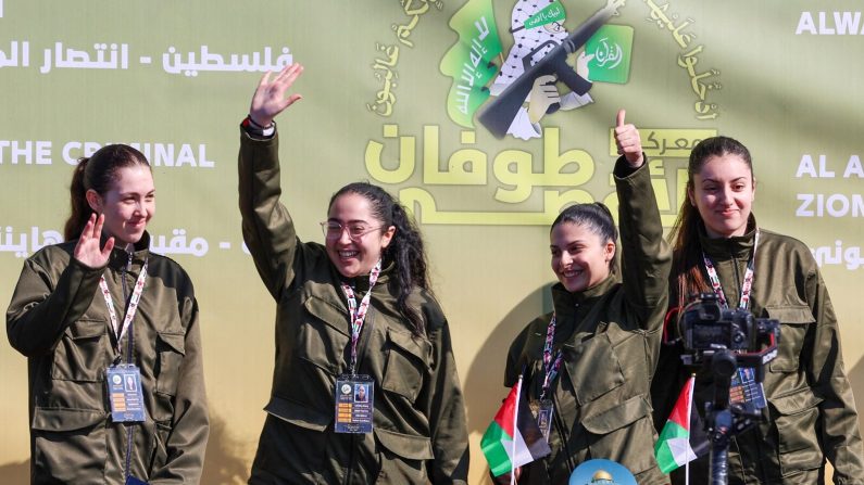 Quatre otages israéliens, (de g. à dr.) Naama Levy, Liri Albag, Daniella Gilboa et Karina Ariev, saluent sur une scène avant que les combattants du Hamas ne les remettent à une équipe de la Croix-Rouge dans la ville de Gaza, le 25 janvier 2025. (OMAR AL-QATTAA/AFP via Getty Images)