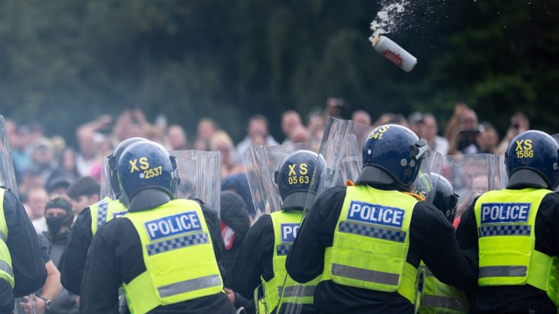 Des policiers anti-émeutes repoussent des manifestants anti- immigration devant l'hôtel Holiday Inn Express qui héberge des demandeurs d'asile, le 4 août 2024 à Rotherham, au Royaume-Uni. (Christopher Furlong/Getty Images)