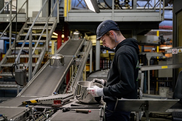 Un employé travaille sur une ligne d'assemblage d'autocuiseurs dans l'usine du groupe SEB à Selongey. (ARNAUD FINISTRE/AFP via Getty Images)