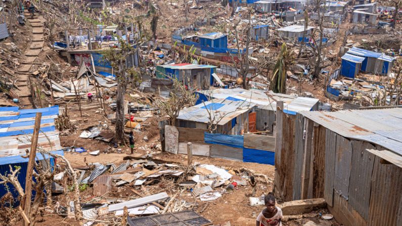 Une jeune fille marche parmi les débris et les abris endommagés dans la ville de Vahibe, à la périphérie de Mamoudzou à Mayotte, le 24 décembre 2024, une semaine après le passage du cyclone Chido sur l'archipel. (PATRICK MEINHARDT/AFP via Getty Images)