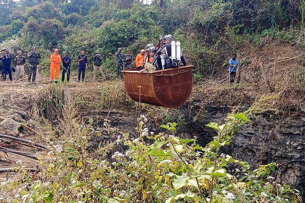 Des plongeurs pénètrent dans un puits inondé d'une mine de charbon à l'aide d'une poulie, afin de secourir des mineurs pris au piège à Umrangso, dans le district de Dima Hasao, dans l'État indien d'Assam, au nord-est du pays, le 7 janvier 2025. Des équipes de recherche indiennes comprenant des plongeurs militaires ont travaillé le 7 janvier pour atteindre plusieurs mineurs coincés sous terre après que l'eau a inondé le puits un jour plus tôt, ont déclaré les responsables des secours. (AFP via Getty Images)