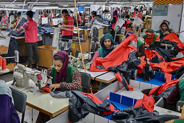 Cette photo prise le 29 décembre 2024 montre des ouvriers du secteur de la confection en train de coudre des vêtements dans une usine textile du groupe Snowtex à Dhamrai, un sous-district de Dhaka. La révolution qui a renversé le gouvernement l'année dernière et dans laquelle les manifestants du secteur de l'habillement ont joué un rôle important a paralysé l'importante industrie de l'habillement du Bangladesh, qui fournit des marques mondiales. (MUNIR UZ ZAMAN/AFP via Getty Images)