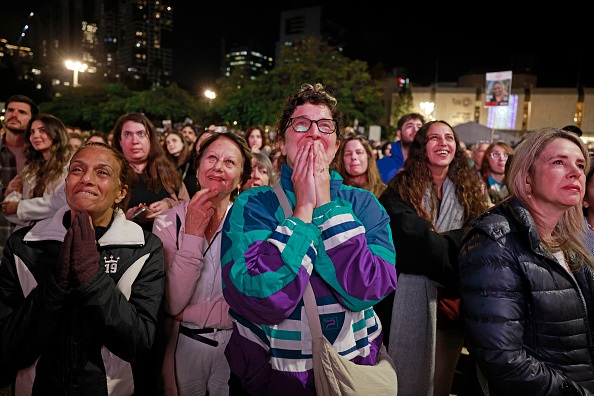 Des partisans et des parents d'otages détenus dans la bande de Gaza depuis les attaques du 7 octobre 2023 par des terroristes palestiniens réagissent en regardant une émission de télévision en direct sur la libération d'otages israéliens, sur la place des otages à Tel-Aviv, le 19 janvier 2025. (Photo MENAHEM KAHANA/AFP via Getty Images)