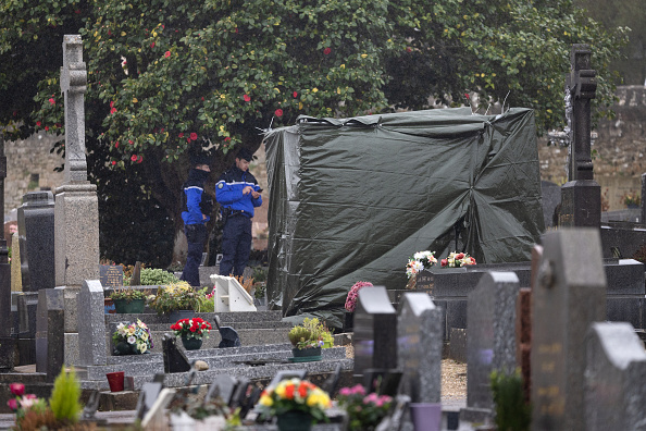 Des gendarmes montent la garde alors qu'une bâche recouvre la pierre tombale vandalisée du défunt de Jean-Marie Le Pen, à La Trinité-sur-Mer, le 31 janvier 2025. (FRED TANNEAU/AFP via Getty Images)