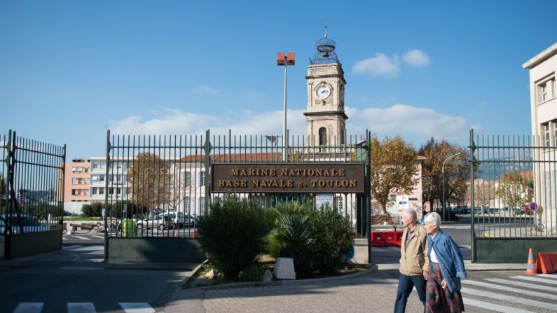 Un couple passe devant l'entrée de la base navale militaire de Toulon, le 11 novembre 2015. (Photo : BERTRAND LANGLOIS/AFP via Getty Images)