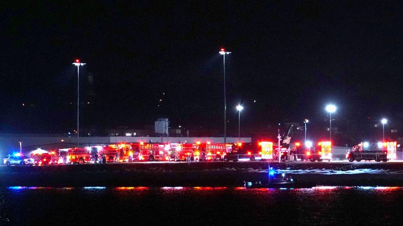 Des unités d'intervention d'urgence attendent sur le tarmac alors que des opérations de recherche et de sauvetage sont en cours dans le fleuve Potomac à l'aéroport Ronald Reagan Washington d'Arlington, en Virginie, le 29 janvier 2025. (Andrew Harnik/Getty Images)