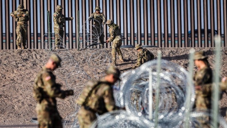 Des soldats de la Garde nationale du Texas déroulent des fils de concertina près de la frontière entre les États-Unis et le Mexique à El Paso, au Texas, le 10 mai 2023. (John Moore/Getty Images)