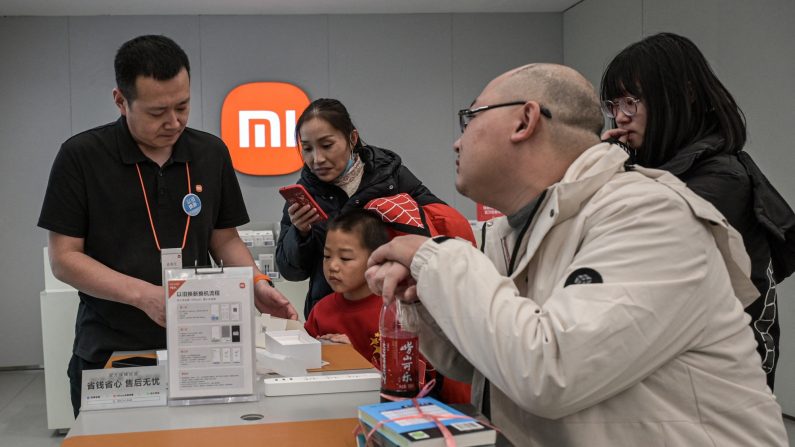 Un représentant de Xiaomi aide des clients dans un centre commercial à Pékin le 15 janvier 2025, dans un contexte économique morose. (JADE GAO/AFP via Getty Images)