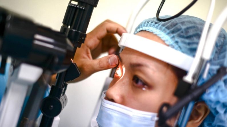 Un professionnel de la santé examine les yeux d'un patient sur une photo d'archives. (Mohd Rasfan/AFP via Getty Images)