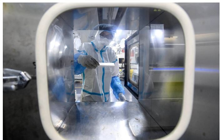 Un technicien de laboratoire travaille sur des échantillons à tester pour le Covid-19 au laboratoire Fire Eye, un centre de test du Covid-19, à Wuhan, en Chine, le 5 août 2021. (STR/AFP via Getty Images)