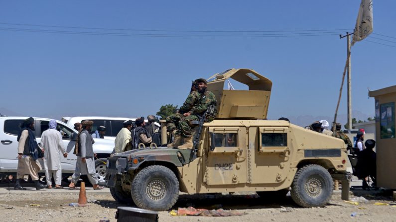 Des talibans attendent d'entrer dans l'ancienne base militaire américaine pour célébrer le premier anniversaire du retrait des troupes américaines d'Afghanistan, à Bagram, en Afghanistan, le 31 août 2022. (Ahmad Sahel Arman/AFP via Getty Images)