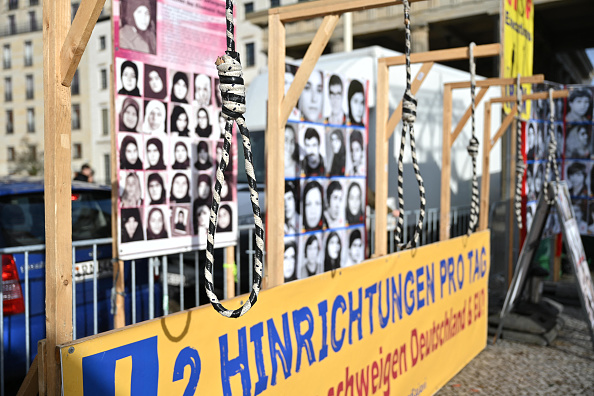 Des portraits sont exposés derrière un nœud coulant alors qu'une pancarte indique « Exécutions pro day » devant la porte de Brandebourg (Brandenburger Tor) lors d'une manifestation de partisans du Conseil national de la Résistance iranienne à Berlin, en Allemagne, le 10 février 2024. (STEFANIE LOOS/AFP via Getty Images)