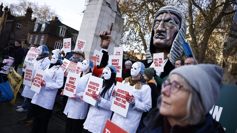 Des militants contre le projet de loi sur le suicide assisté brandissent des pancartes lors d'une manifestation devant le Palais de Westminster, dans le centre de Londres, le 29 novembre 2024. (BENJAMIN CREMEL/AFP via Getty Images)