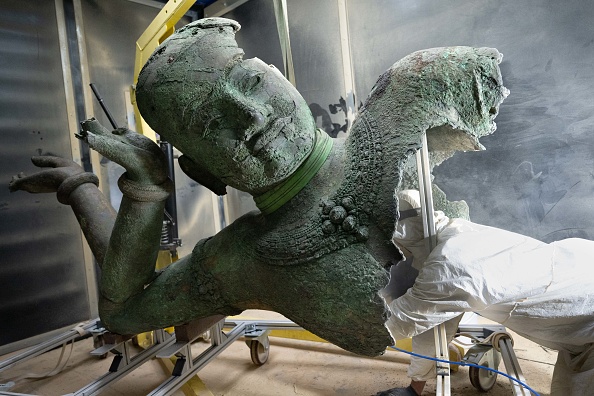 Un technicien travaille sur Le Vishnu couché du Mébon occidental en cours de restauration au Laboratoire départemental Arc'Antique à Nantes, le 12 février 2025. (SEBASTIEN SALOM-GOMIS/AFP via Getty Images)