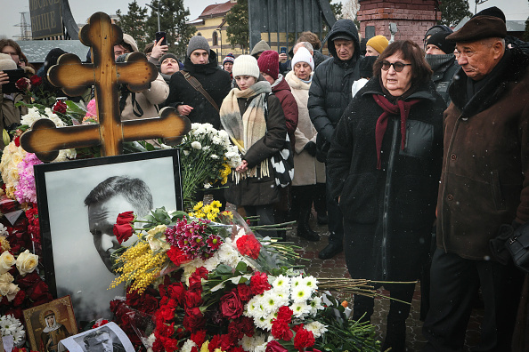 Anatoly Navalny (à droite) et Lyudmila Navalnaya (2e à droite), parents du défunt leader de l'opposition russe Alexei Navalny, rendent hommage à leur fils sur sa tombe au cimetière de Borisovo, marquant le premier anniversaire de sa mort alors qu'il était incarcéré dans une colonie pénitentiaire isolée de l'Arctique, à Moscou, le 16 février 2025.  (ALEXANDER NEMENOV/AFP via Getty Images)