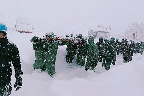 Sur cette photo prise et diffusée par la State Disaster Response Force (SDRF) le 28 février 2025, des sauveteurs transportent des travailleurs de la Border Roads Organisation (BRO) après une avalanche près du village de Mana dans le district de Chamoli. (Photo State Disaster Response Force (SDRF)/AFP via Getty Images)