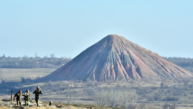 Des soldats devant le terril d'une mine de charbon sur la position des forces ukrainiennes sur la ligne de front près de la petite ville de Kurakhove, dans la région de Donetsk, le 11 mars 2015. (SERGEI SUPINSKY/AFP via Getty Images)