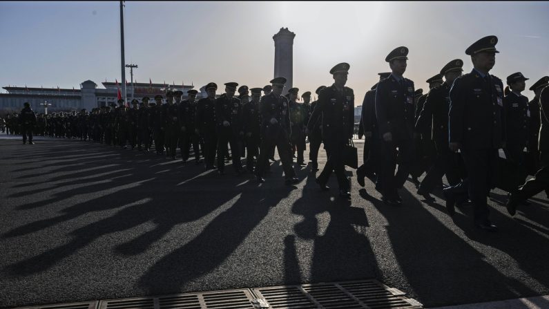 Des délégués militaires chinois marchent en ligne à leur arrivée à la deuxième session plénière de l'assemblée législative chinoise, le Congrès national du peuple, dans le Grand Hall du peuple à Pékin, le 8 mars 2024. (Kevin Frayer/Getty Images)