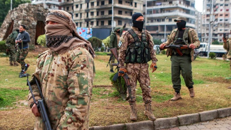 Des combattants affiliés au nouveau régime syrien montent la garde dans les rues de la ville côtière occidentale de Lattaquié, en Syrie, le 26 décembre 2024. (Aaref Watad/AFP via Getty Images)