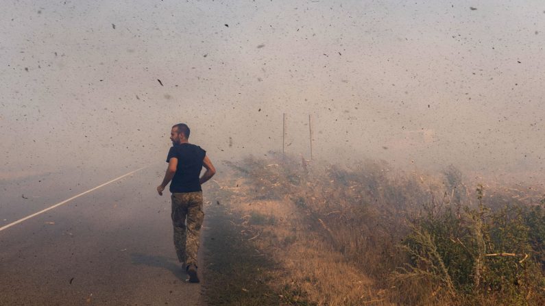 Un soldat ukrainien court pour aider des fermiers à éteindre un champ en feu près de Pokrovsk, dans la région de Donetsk, pendant l'invasion russe de l'Ukraine, le 16 septembre 2024. (Oleksii Filippov/AFP via Getty Images)