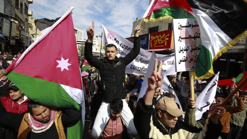 Des manifestants portent des drapeaux et des banderoles alors qu'ils protestent contre la proposition du président Donald Trump pour que les États-Unis prennent le contrôle de la bande de Gaza et déplacent plus de 2 millions de Palestiniens hors du territoire, à Amman, en Jordanie, le 14 février 2025. (Khalil Mazraawi/AFP via Getty Images)