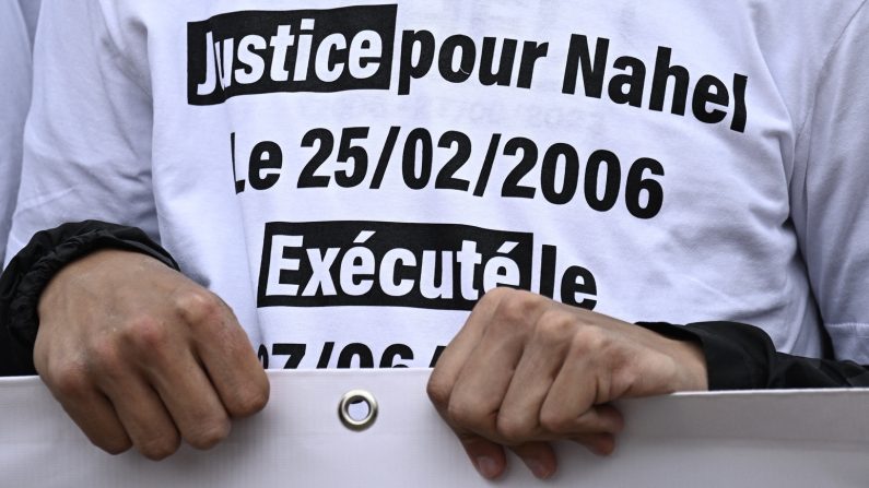 Un manifestant porte un T-shirt sur lequel on peut lire « Justice pour Nahel, né le 25/02/2006, exécuté le 27/06/2023 » lors d'une marche en hommage à Nahel, un jeune de 17 ans tué après un refus d'obtempérer en 2023, à Nanterre. (Crédit photo JULIEN DE ROSA/AFP via Getty Images)