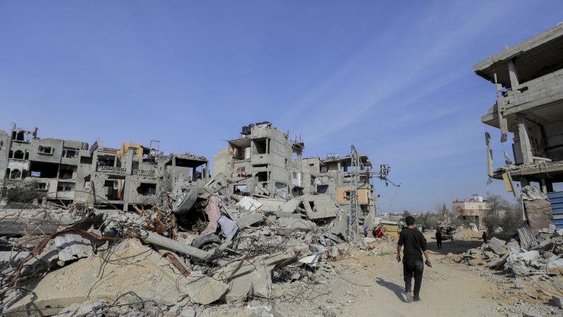 Un homme passe devant des bâtiments détruits et des débris épars au nord du camp d'Al-Bureij, à Gaza, le 2 février 2025. (MOIZ SALHI/Middle East Images/AFP via Getty Images)