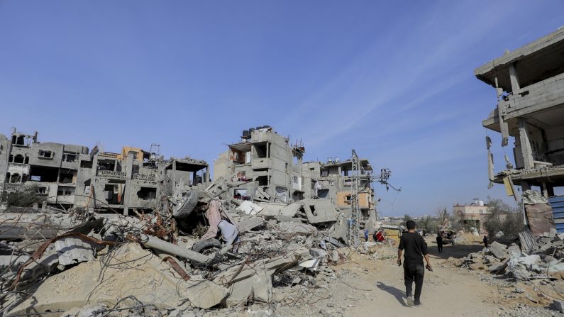 Un homme marche parmi des bâtiments détruits et des débris éparpillés au nord du camp d'Al-Bureij, à Gaza, le 2 février 2025. (MOIZ SALHI/Middle East Images/AFP via Getty Images)