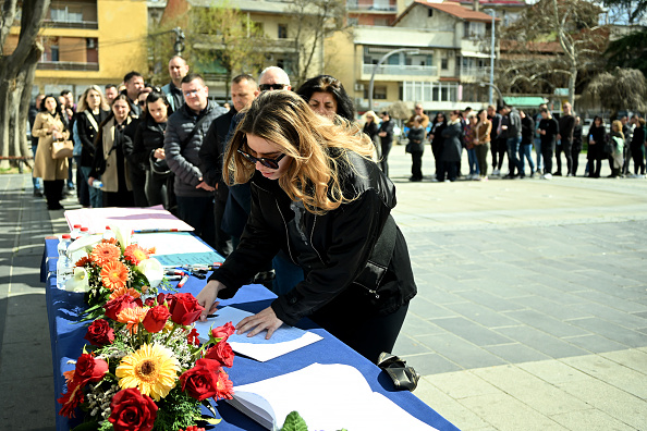 Une femme signe un livre de condoléances à Kocani le 17 mars 2025, un jour après qu'un incendie a ravagé une discothèque bondée, en Macédoine du Nord. (ROBERT ATANASOVSKI/AFP via Getty Images)