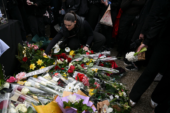 Des étudiants déposent des fleurs le 17 mars 2025 lors d'un rassemblement à l'université de Skopje au cours d'une cérémonie commémorative, un jour après qu'un incendie ait ravagé une boîte de nuit surpeuplée et remplie de jeunes en Macédoine du Nord.  (Crédit photo ARMEND NIMANI/AFP via Getty Images)