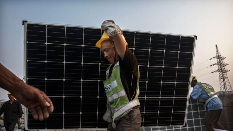 Un ouvrier chinois porte un panneau solaire à Huainan, dans la province d'Anhui, en Chine. (Kevin Frayer/Getty Images)