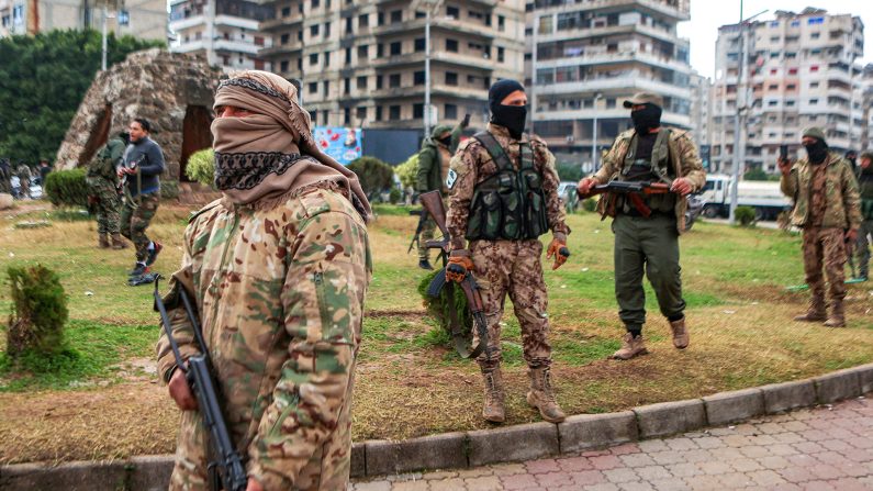 Des combattants affiliés au nouveau régime syrien montent la garde dans les rues de la ville côtière occidentale de Lattaquié, en Syrie, le 26 décembre 2024. (Aaref Watad/AFP via Getty Images)