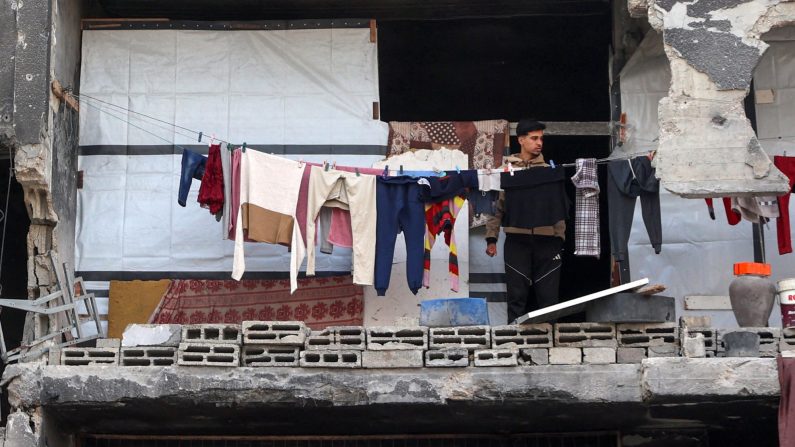 Un Palestinien se tient sur le balcon d'un bâtiment endommagé où il s'est réfugié à Beit Lahia, dans le nord de la bande de Gaza, le 9 mars 2025. Omar al-Qattaa/AFP via Getty Images