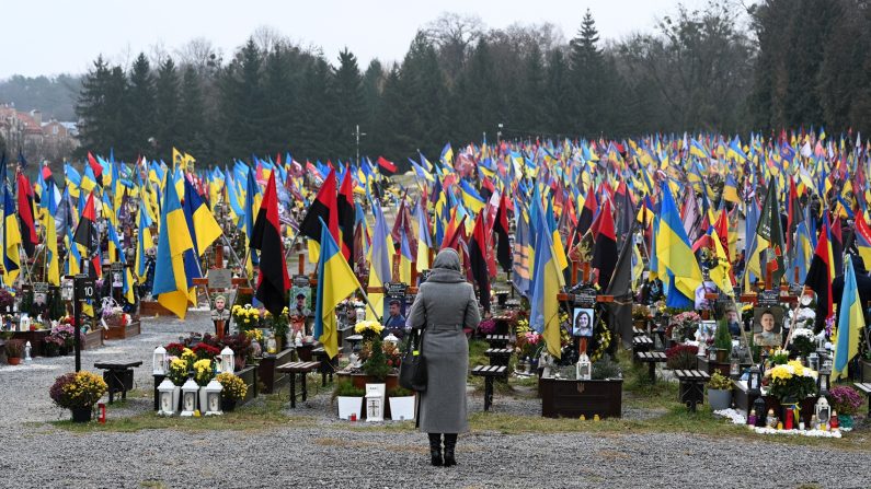 Une femme se rend au cimetière de Lychakiv lors de la Journée des forces armées ukrainiennes, à Lviv, le 6 décembre 2024, sur fond d'invasion russe de l'Ukraine. (YURIY DYACHYSHYN/AFP via Getty Images)