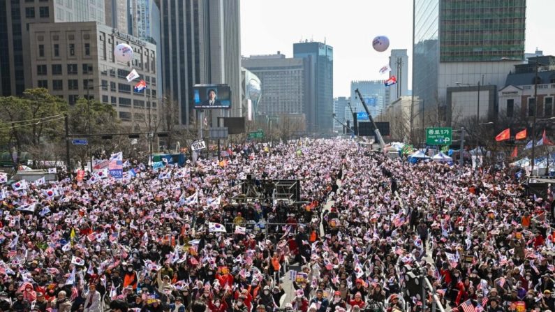 Des partisans du président sud-coréen Yoon Suk Yeol, arrêté et destitué, agitent des drapeaux sud-coréen et américain lors d'un rassemblement dans le centre-ville de Séoul, le 8 mars 2025. (Jung Yeon-je/AFP via Getty Images)