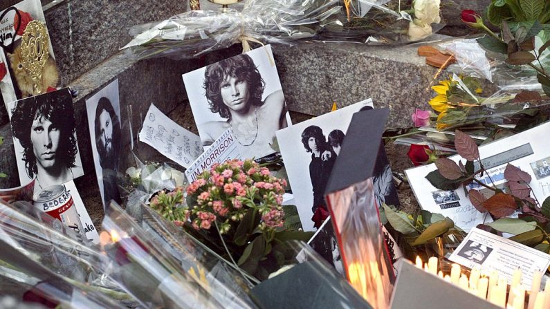 Des photos et des fleurs sur la tombe de Jim Morrison au cimetière du Père Lachaise, le 8 décembre 2003 à Paris. (JOEL ROBINE/AFP via Getty Images)